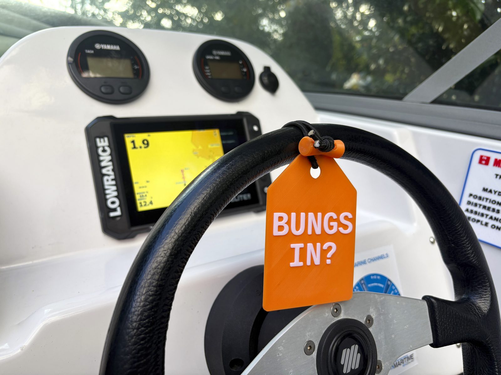 Orange Bungs In reminder tag hanging on a boat steering wheel